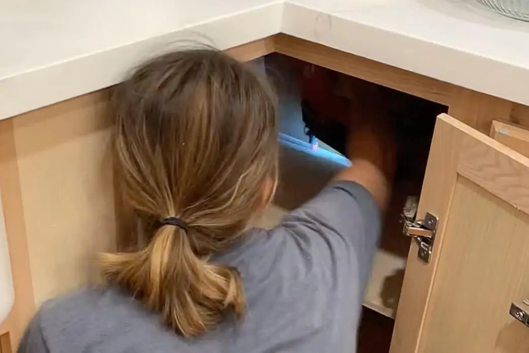 Attaching a shelf in a kitchen cabinet with a brad nailer.